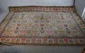 A large beige ground Persian carpet with all over stylistic floral design. W.220 L.327cm