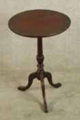 A Georgian style mahogany wine table with turned central column raised on three splayed supports