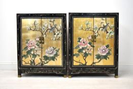 A pair of 20th century Chinese lacquered twin door cabinets with applied decoration of a bird in a