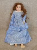 A 20th century papier mache faced clothed female doll with articulated limbs.