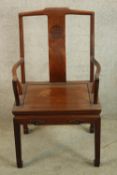 A 20th century Chinese hardwood splat back open armchair raised on tapering supports terminating