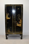 A contemporary Chinese lacquered twin door three shelved cabinet decorated with figures looking at