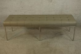 A contemporary Knoll style button grey leather seated bench raised on chome plated square