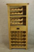 A contemporary oak floor standing wine bottle cabinet raised on square supports. H.161 W.72cm.