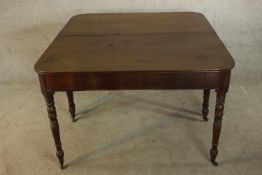 A George III mahogany D end dining table raised on turned supports terminating in brass casters. H.