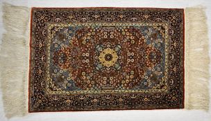 A 20th century Iranian/Persian silk rug with all over stylised floral decoration. L.94 W.62.5cm