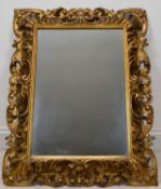 A late 19th/early 20th century Italian style rectangular carved gilt framed wall mirror. H.83.5 W.