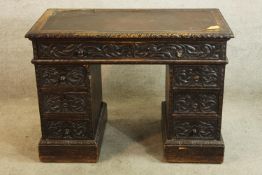 A 19th century carved oak twin pedestal writing desk raised on plinth base. H.76 W.104cm.