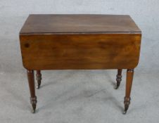 A 19th century mahogany Pembroke table raised on turned supports terminating in brass casters. H.