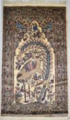 A Persian silk and wool tree of life rug, the ivory field with a crane and assorted flowers within a