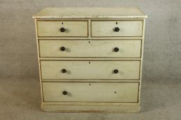 A Victorian painted chest of two short over three long drawers with turned handles raised on