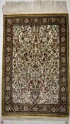 A Persian/Iranian silk Qum (Qom) rug, the central ivory field with tree of life within floral