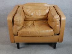 A contemporay Heals brown leather tub chair with loose cushions raised tapering supports, with
