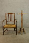 A 19th century mahogany framed splat back open arm chair with straw seat raised on tapering supports