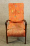 A mid 20th century mahogany effect open arm upholstered nursing chair raised on square supports.