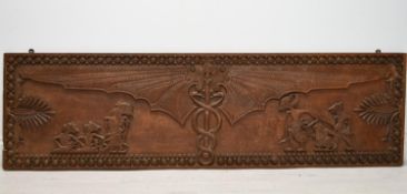 A South East Asian carved hardwood panel depicting bat wings with intertwining snakes and mythical