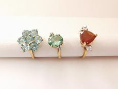 Three 20th century 10 carat gold gem-set rings: a fire opal and cubic zirconia flanked solitaire
