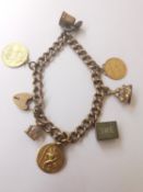 A 9 carat rose gold curb link charm bracelet with an inscribed heart padlock clasp. Bracelet has 7