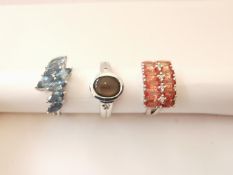 Three 20th century 9 carat gold gem-set rings: a cross over blue topaz ring, a black star sapphire