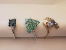 Three 20th century 9 carat gold gem-set rings: a solitaire blue diamond ring, set with a round mixed