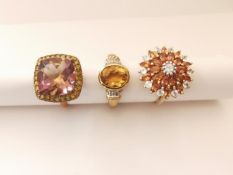 Three 20th century 9 carat gold gem-set rings: an orange and white sapphire sun design dress ring,