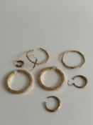 A collection of seven 9 carat yellow gold hoop earrings. Three pairs of earrings, one twisted design