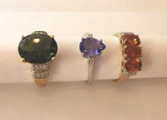 Three 20th century 10 carat gold gem-set rings: a diamond and Tanzanite drop shape flanked solitaire