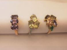 Three 20th century 10 carat yellow gold gem-set rings: a three stone cross over ring set with pale