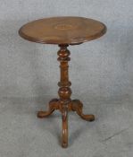 A 19th century circular inlaid walnut tripod table with turned central column raised on three