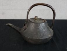 A 19th/early 20th century Japanese cast iron teapot with swing handle. H.15 W.21 D.15cm