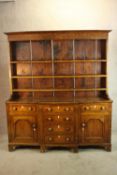 A 19th century oak kitchen dresser with plate rack back raised on breakfront base with central