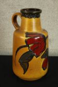 A mid 20th century West German pottery pitcher jug tubelined with floral decoration, marks to