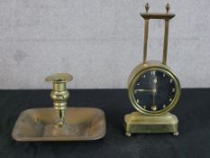 A vintage brass cased gravity clock, the black dial with white painted Arabic numerals raised on