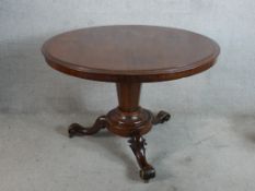 A William IV mahogany circular topped table raised on tapering octagonal column with carved supports