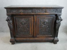 A Jacobean style S. Goff & Son carved oak sideboard, with two short doors and two cupboard doors