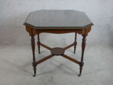 An Edwardian mahogany octagonal centre table raised on 'X' stretcher and turned supports termating