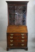 A George III mahogany bureau bookcase, the twin glazed doors opening to reveal adjustable shelves