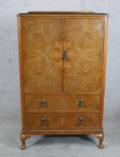 A Georgian style burr walnut veneered twin door drinks cabinet opening to reveal adjustable