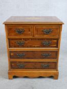 A Georgian style walnut and yew veneered chest of two short over three long drawers raised on shaped