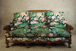 A Georgian style carved beech framed bergere three seater settee raised on cabriole supports and
