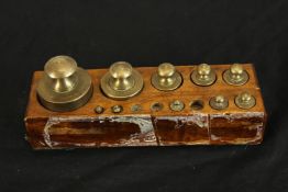 Block of brass weights. Incomplete with three of the lighter weights missing. H.9 x W.22 cm.