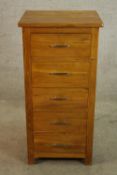 A contemporary oak five drawer tallboy with brass handles raised on square supports. H.104 W.51cm.