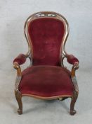 A 19th century mahogany show framed button back spoonback armchair raised on carved cabriole