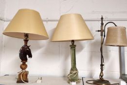 Three early 20th century table lamps, one carved alabaster in the form of the knight chess piece.