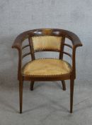 An early 20th century inlaid mahogany framed bow back chair with studded leather seat and back