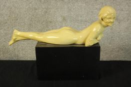 An Art Deco style figure. A reclining nude. Painted plaster. H.25 W.36cm.