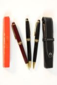 Three Mont Blanc Meisterstuck black lacquer ballpoint pens with gold plated detailing along with a