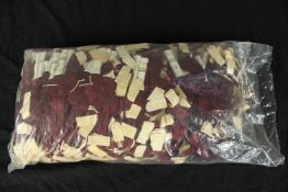 A collection of maroon/ burgundy silk threads. In manufacturers seal.
