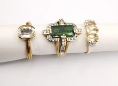 Three 20th century 9 carat gold gem-set rings, a topaz three stone ring, a tourmaline and diamond
