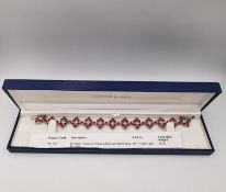 A boxed 9ct white gold Tanzanian ruby and diamond articulated bracelet. The bracelet set with a